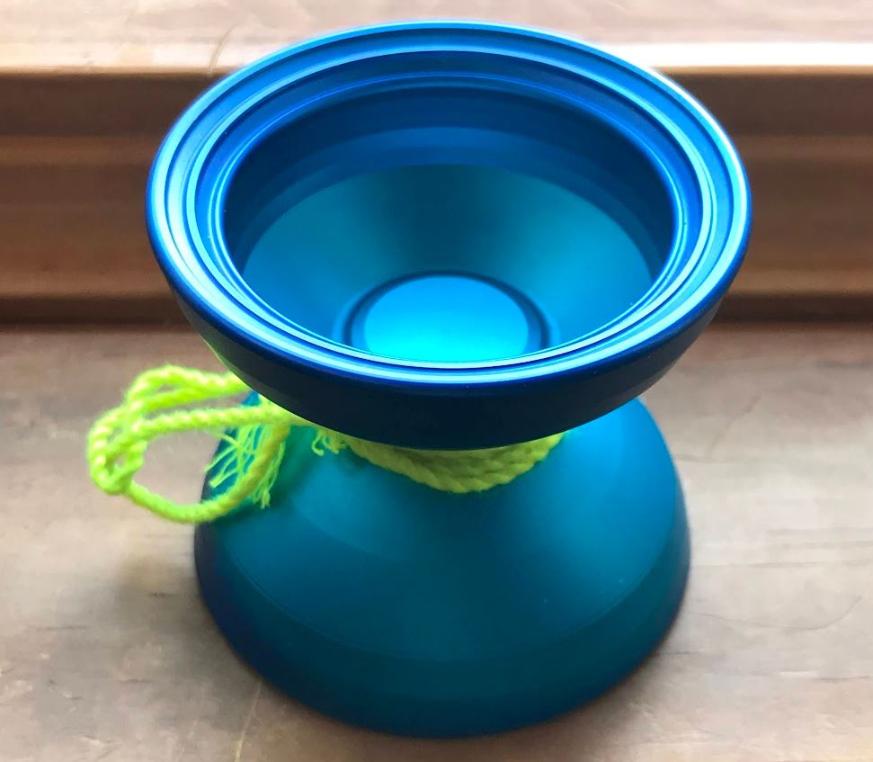 matte blue yoyo on a desk with a neon yellow string wrapped around it